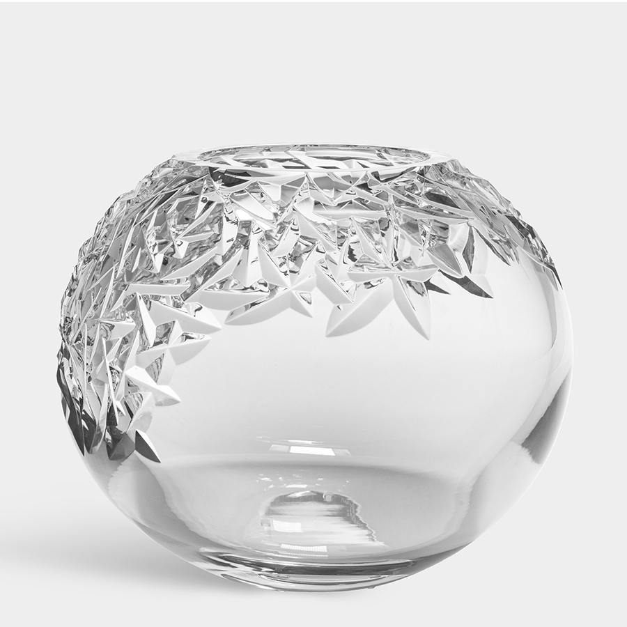 The Orrefors: Carat Globe Vase XL is a round, clear crystal vase featuring intricate, angular cut patterns on the upper half, showcasing its status as a true masterpiece.