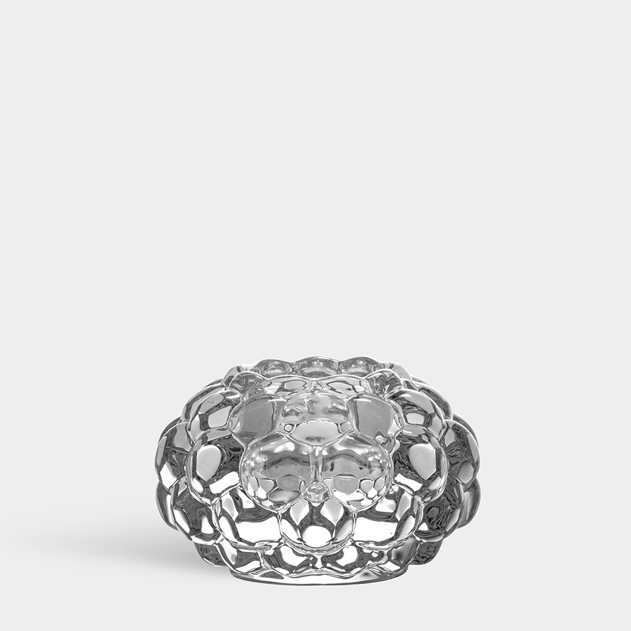 The Orrefors Raspberry votive candle holder medium showcases a honeycomb-like pattern, reminiscent of the elegance found in clear crystal designs.