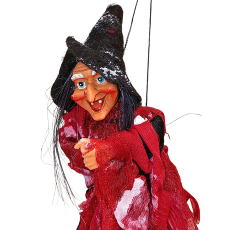 The Kitchen Witch: Walburga Red Kitchen Witch Doll is a handmade German marionette with a pointed hat, long black hair, red clothing, and exaggerated features—a charming good luck charm shown against a white background.