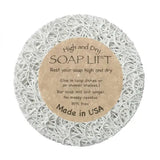 The Soap Lift: Round A Bout Soap Lift Soap Saver is a white, round pad with a textured web-like surface and brown label. It keeps bar soap dry and mess-free, is eco-friendly, BPA free, Made in USA.