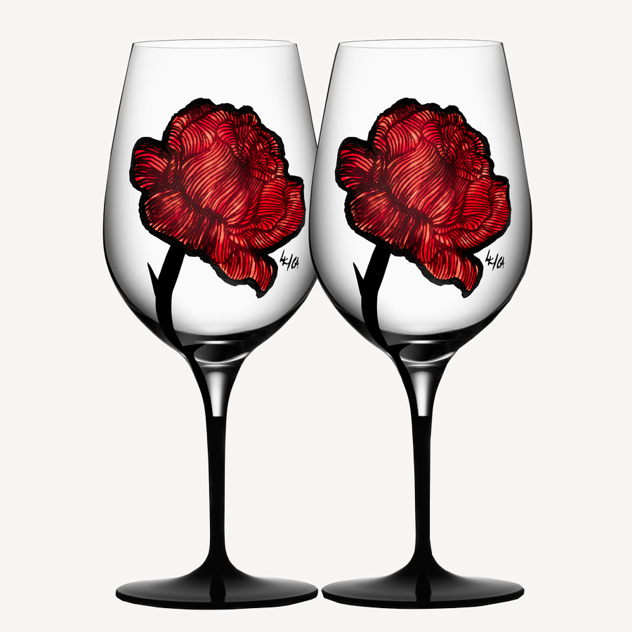 The KostaBoda: Tattoo Wine Glass (2-Pack) showcases hand-painted red rose designs on transparent bowls with sleek black stems, arranged side by side.