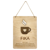 Wooden plaque with a steaming cup cutout, heart detail, and the word “FIKA” in bold letters, referencing the Swedish coffee break tradition.