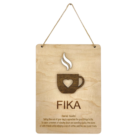 Wooden plaque with a steaming cup cutout, heart detail, and the word “FIKA” in bold letters, referencing the Swedish coffee break tradition.