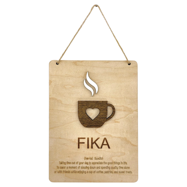 Wooden plaque with a steaming cup cutout, heart detail, and the word “FIKA” in bold letters, referencing the Swedish coffee break tradition.