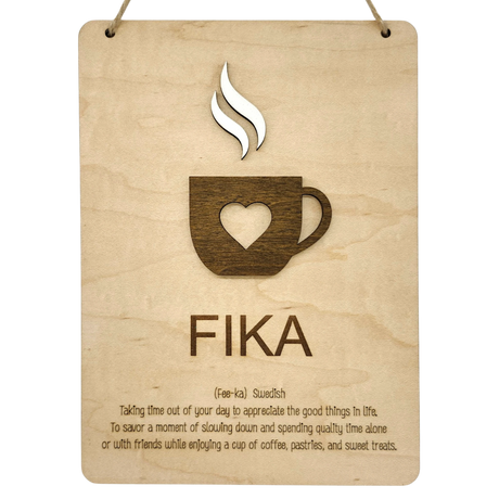 Wooden wall plaque with a coffee cup and heart cutout, labeled FIKA in bold letters. Scandinavian design elements visible.
