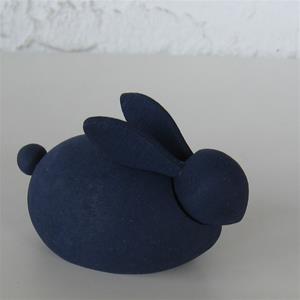 The Figurine: Swedish Handcrafted Wooden Rabbit is a small, smooth, navy blue masterpiece of Swedish craftsmanship displayed on a light surface.