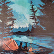 Two people sit by a campfire near an orange tent and lake, surrounded by trees under a blue sky—a cozy Minnesota camping scene captured on the S'mores Campfire Coaster by Adam Turman.