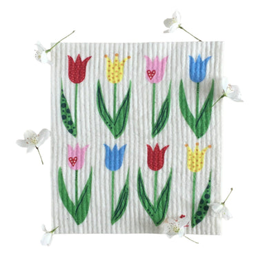 The Dish Cloth: Tulips Swedish Dishcloth, featuring vibrant tulips in red, yellow, pink, and blue with delicate white flowers, adds charm to your kitchen while promoting an eco-friendly lifestyle with its biodegradable material.