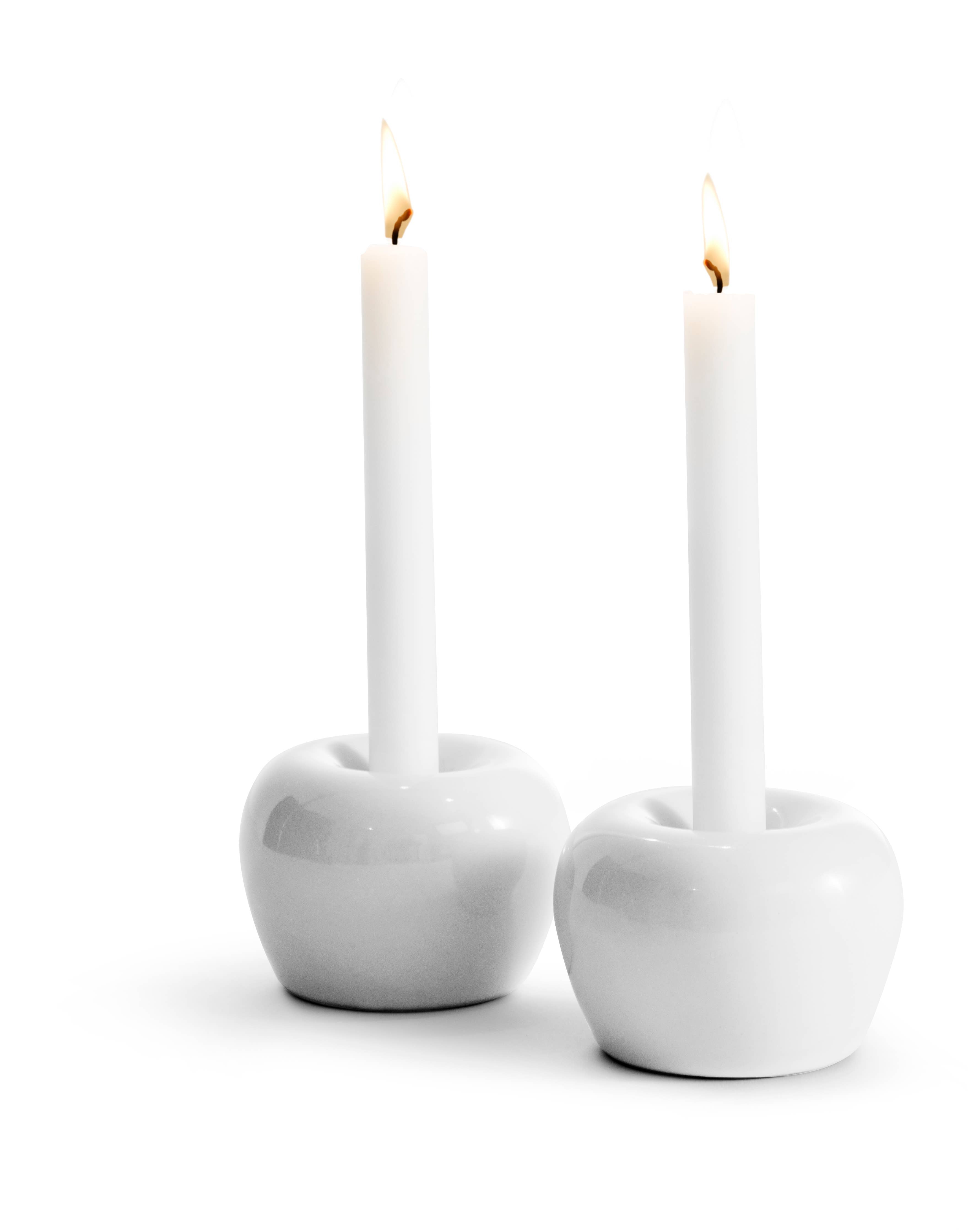 Two lit white candles in elegant round stoneware holders (Apple Candleholder 2-Pack Mini Apple) on a plain background.