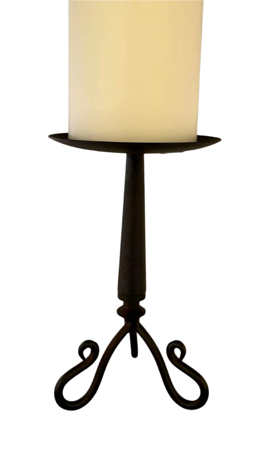 A white candle on a metal rustic finish candle holder with a twisted base design and three legs (6" x 3").