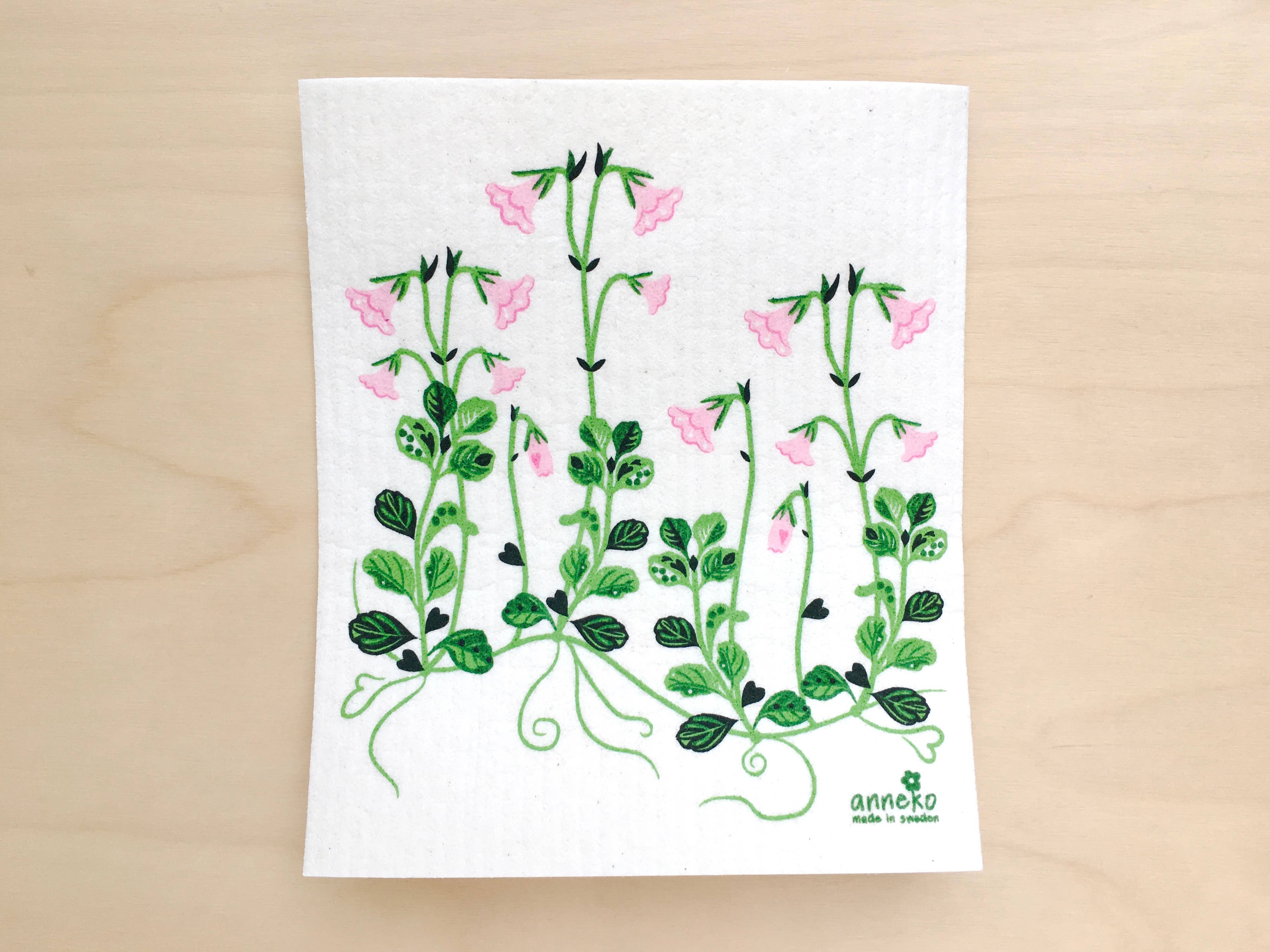 The Linnaea Swedish Dishcloth features a green and pink floral design with small flowers and leafy vines. This eco-friendly dishcloth is biodegradable and thoughtfully made in Sweden.