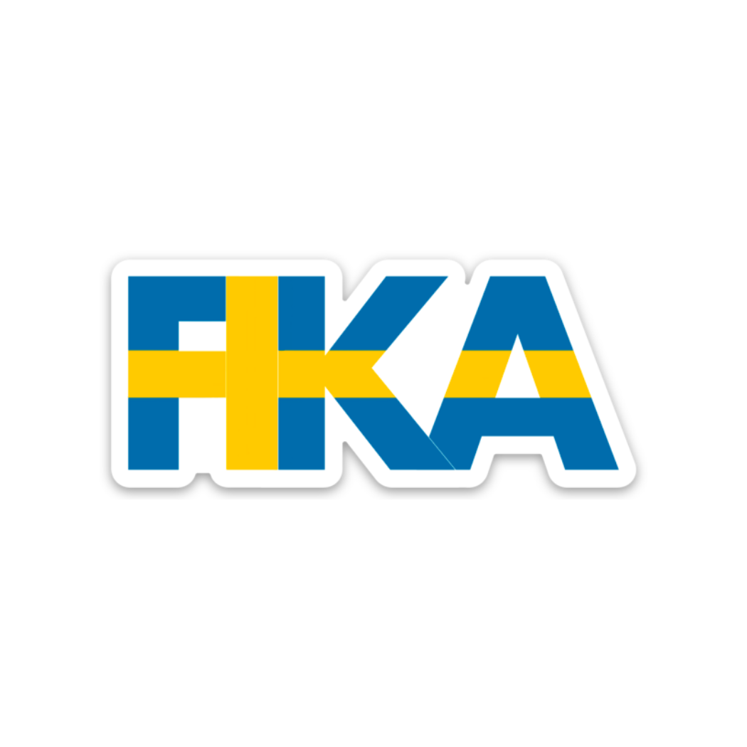 The image showcases the word on the product "Sticker: Fika - Sticker" in blue, featuring a hand-drawn yellow cross that resembles the Swedish flag.