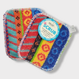 Two colorful rectangular Skoy Scrub Cloths by Skoy Enterprises, featuring geometric patterns in red, orange, blue, green, and yellow, are displayed side by side as eco-friendly kitchen scrubbers from the Good Clean Fun! collection.