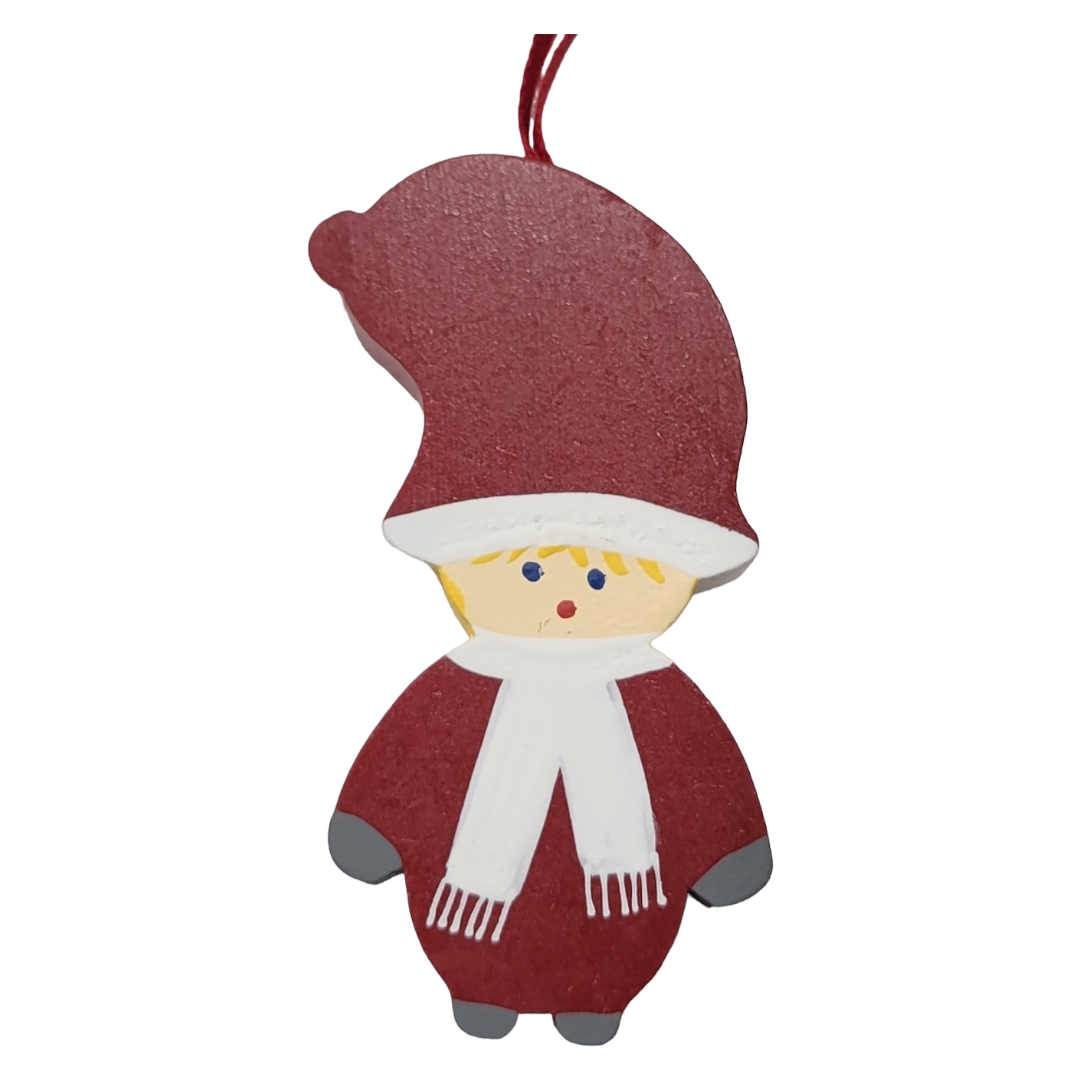 The Ornament: 3" Tomte Boy is a delightful wooden figurine depicting a Swedish character in a red hat and outfit, accented with a white scarf and suspended by a red string. It beautifully embodies the essence of Scandinavian charm.