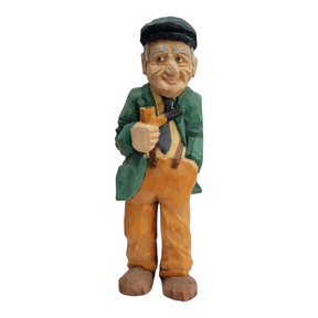 Product Description: "Man w/Pipe" by Bill Erickson is a wood-carved figurine of an elderly man standing 8 1/2 inches tall, wearing a cap, green jacket, and orange pants. He holds a pipe and a book.