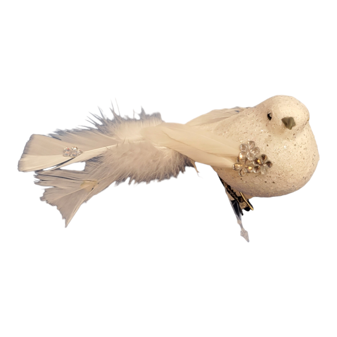 An ornamental bird clip featuring feathered wings and tail, adorned with small jewels in a decorative white design.