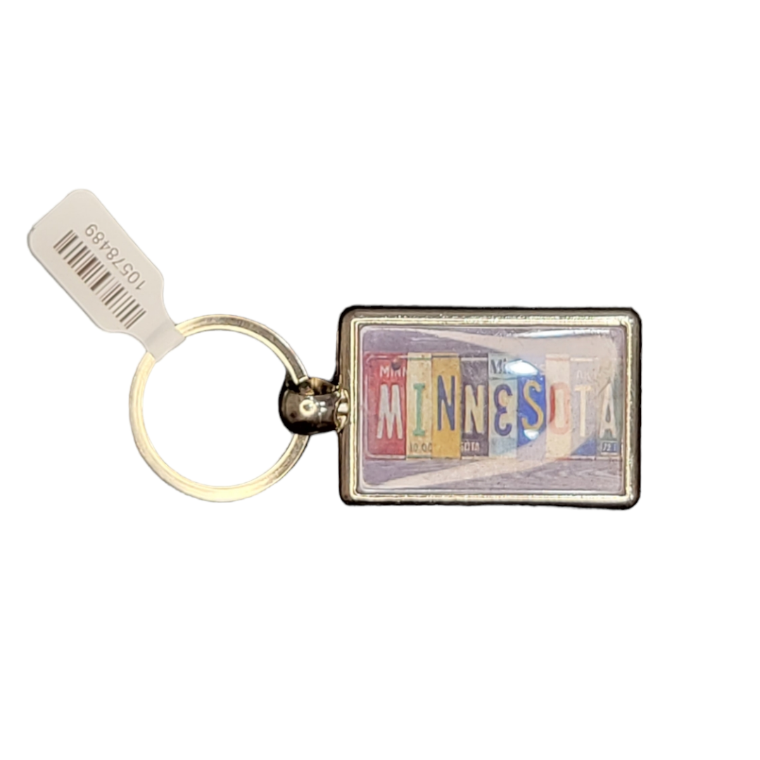 The Keychain: MN Vintage License Plate showcases a rectangular design with the word Minnesota composed of letters from license plates, capturing a vintage Americana vibe. It’s affixed to a ring and accented with a white price tag marked 105-36189.