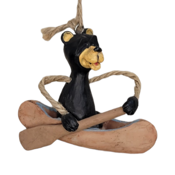 The "Ornament: Bear in Canoe" features a charming carved wooden bear figurine expertly holding a paddle while sitting in a canoe, and it comes with a sturdy rope hanger. This delightful piece captures nature's playful spirit similar to the realism found in detailed resin ornaments.