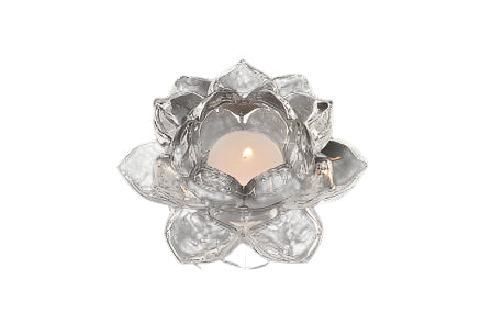 A lit tea candle in a 5 Lotus Glass Tealight Candle Holder rests on a dark marbled surface, casting gentle reflections.