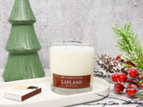 The Lapland Candle by Fjord & Fable features a balsam fir, clove, and cedar blend in an 8 oz glass with two wicks—perfect for creating a woodsy holiday atmosphere beside festive decor.