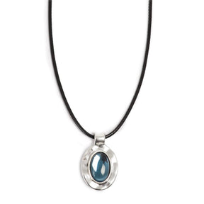 The A&C Oslo Silver Deep Blue Glass Necklace features a glossy deep blue glass stone set in a silver oval pendant on a black cord.