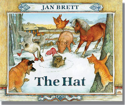 The cover of Jan Bretts book The Hat (Board Book) features a snowy scene with Hedgie the hedgehog in a red hat, surrounded by curious animals like a horse, pig, and dogs—all fascinated by his new look.
